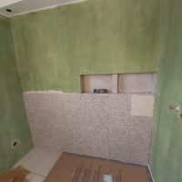 Pose de pierre naturelle en cours dans une salle de bain étanchéifiée – chantier à Bavilliers