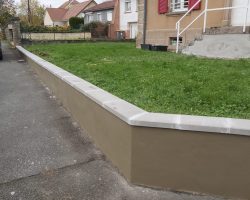 Muret de clôture rénové avec enduit et chaperons béton à Denney– travaux signés WT TOUS TRAVAUX